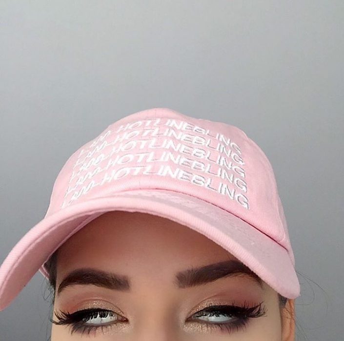 mujer con gorra rosa pastel rueda los ojos