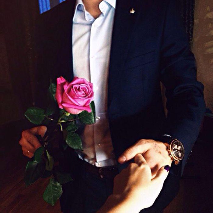 hombre caballero con una rosa toma la mano de mujer