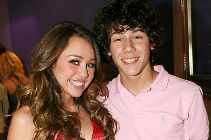 chica sonriendo con chico de playera rosa novios