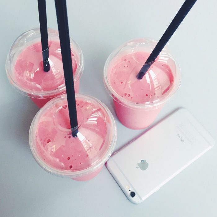 3 bebidas rosas con popote y un iphone 