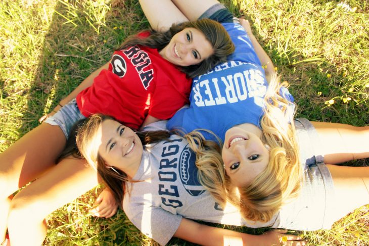 tres amigas en el césped se toman foto 