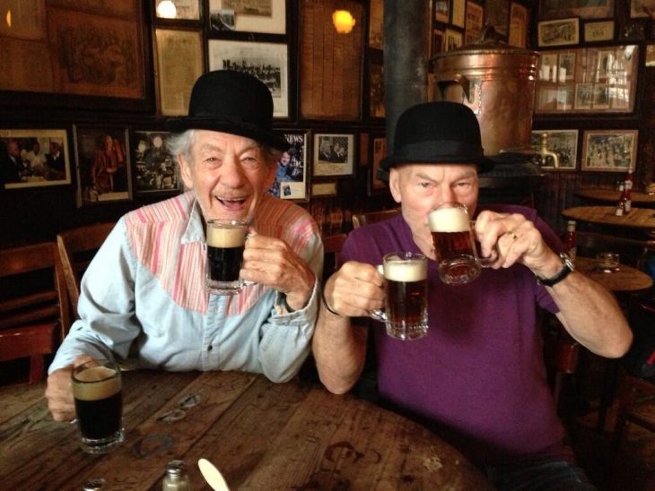 dos hombres mayores con sombrero y cerveza en bar 