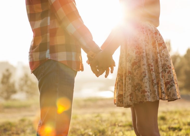 pareja tomados de la mano en el campo