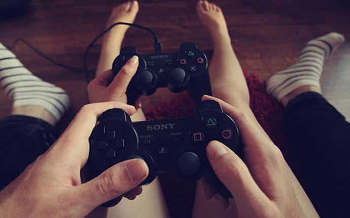 manos de pareja jugando videojuegos