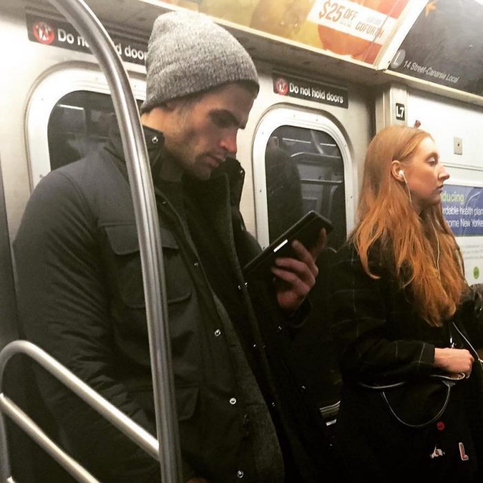 hombre de gorra gris leyendo un libro en el metro 