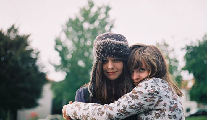 chica abrazando a su amiga con gorro