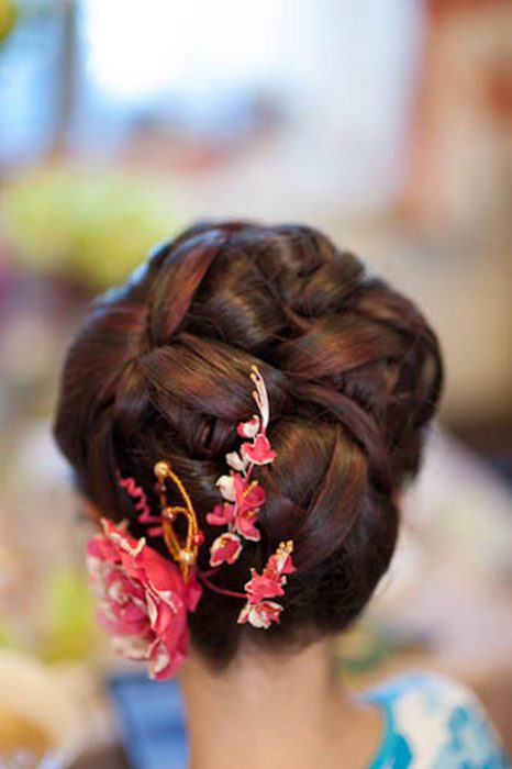 chica con peinado de chongo y flores rosas 