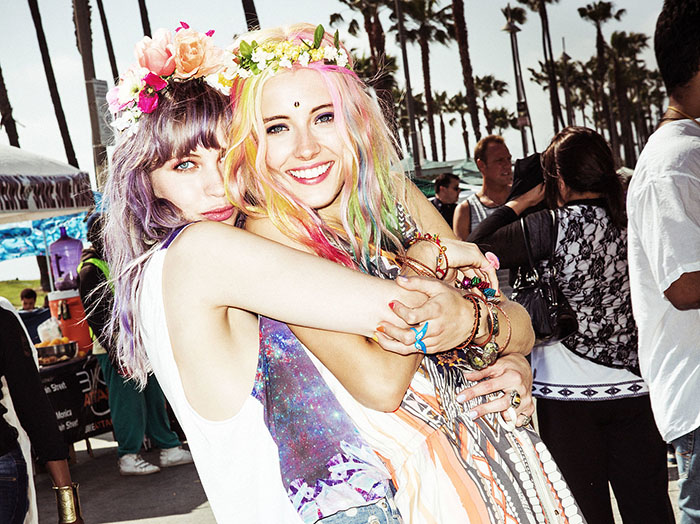 amigas sonriendo con cebello morado y flores en la cabeza 