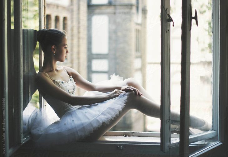 chica con tutu ballerina sentada en la ventana 