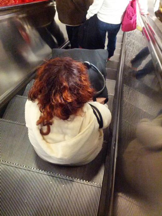 mujer sentada en escalera eléctrica
