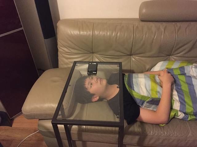 niño viendo celular a través de vidrio