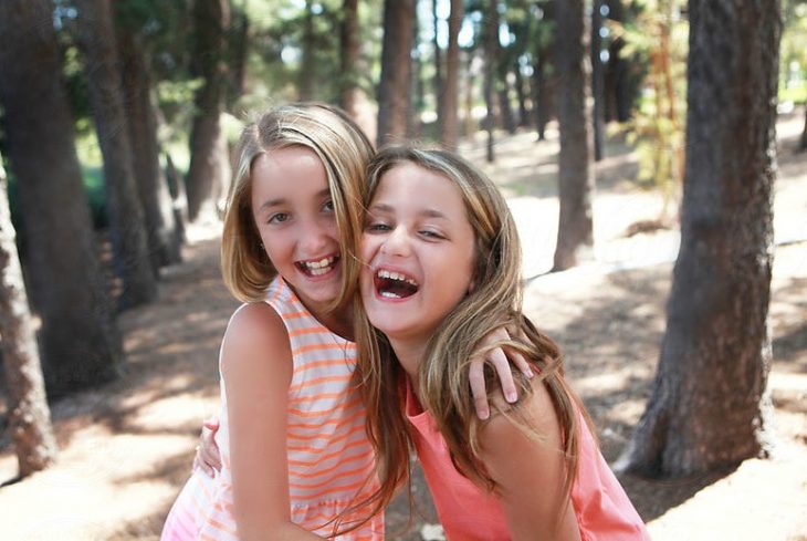 amigas niñas sonriendo felices se abrazan 