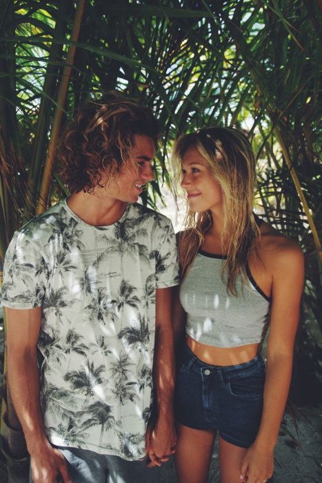 Pareja de novios en la playa viéndose uno al otro