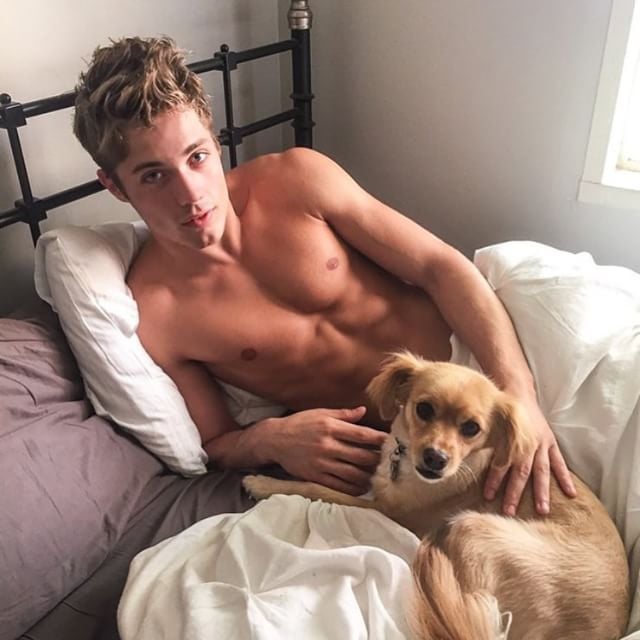 Chico acostado en la cama con su perro 