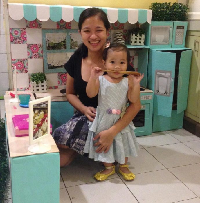 Madre e hija jugando en una cocina con cajas de cartón 