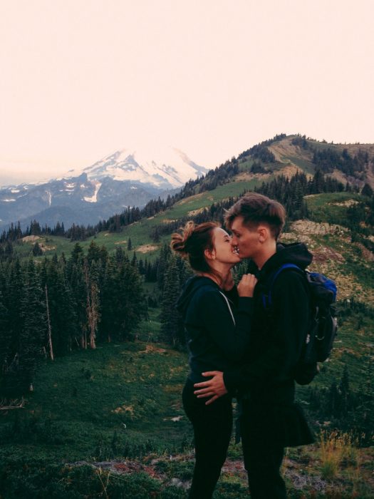 Pareja en una montaña besándose 