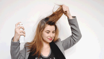 GIF Chica aplicándose champú seco en el cabello