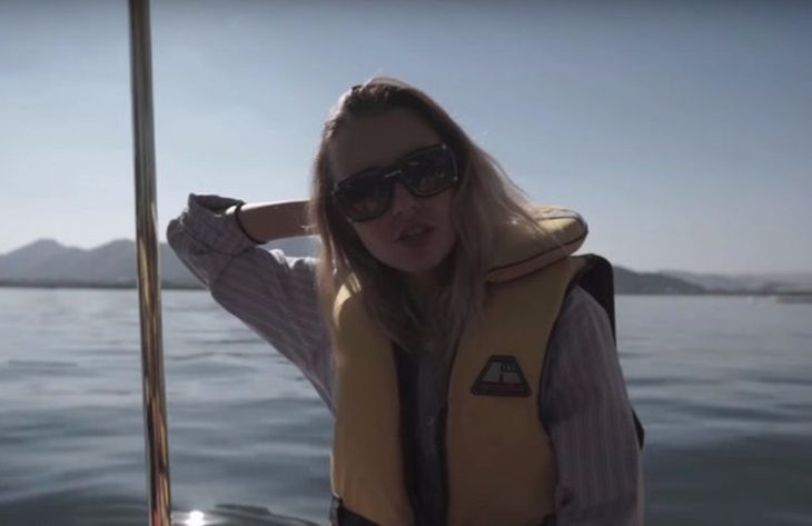 mujer rubia en unb barco con salvavidas 