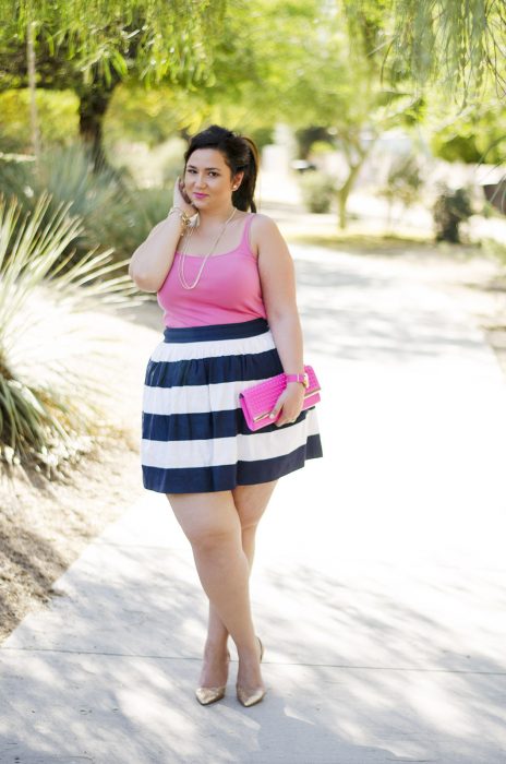 Chica plus size vistiendo una falda en color azul con blanco y una blusa color rosa 