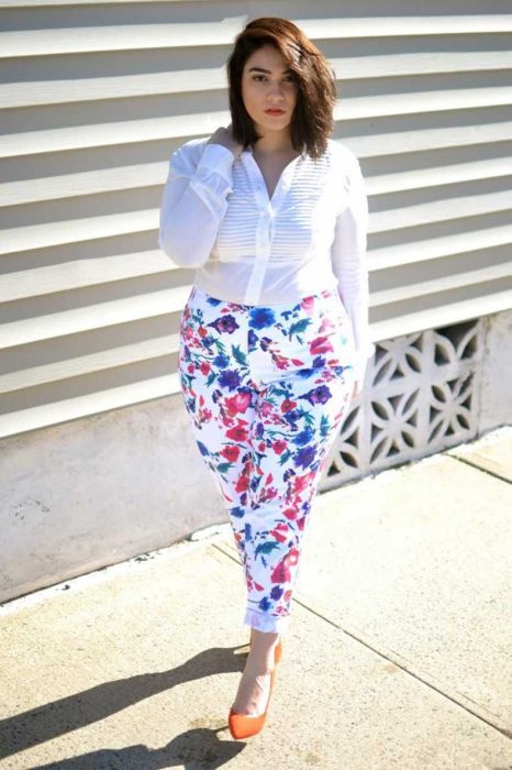 Chica plus size usando un pantalón con estampados y una blusa blanca 