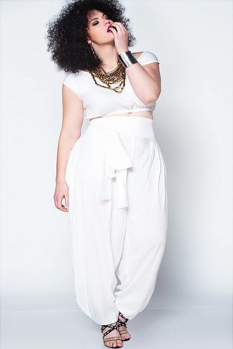 Chica plus size usando un pantalón y un crop top blancos