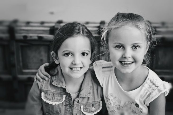 dos niñas sonriendo abrazadas 