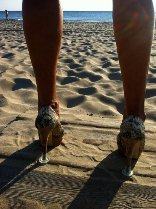 mujer con tacones en la playa 