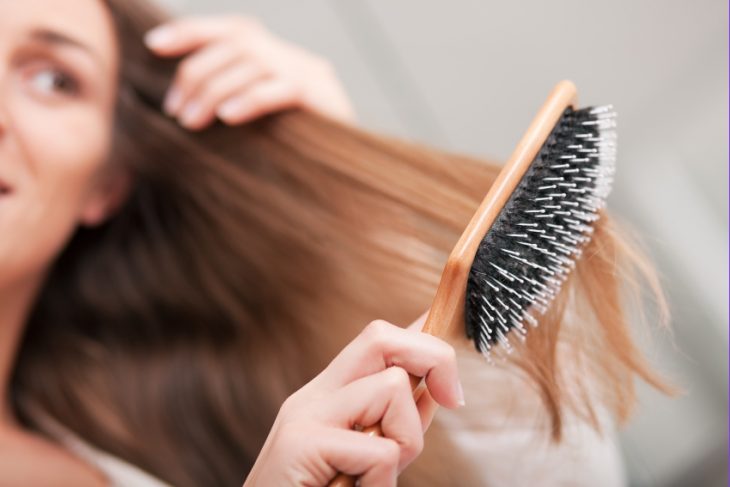 chica cepillándose el cabello