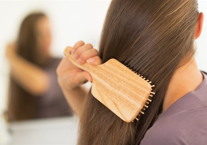 mujer cepillando cabello