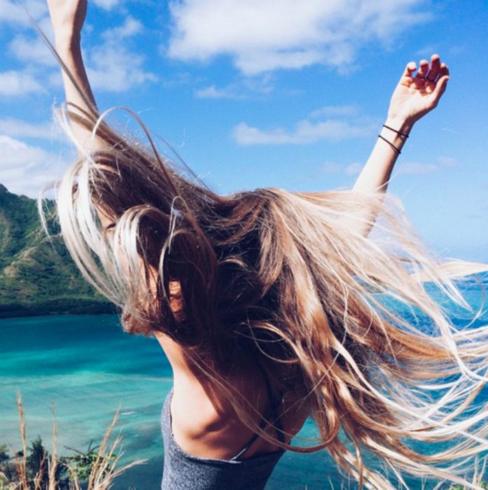 Chica bailando frente a la playa 