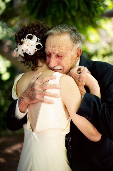 Chica el día de su boda abrazando a su abuelo