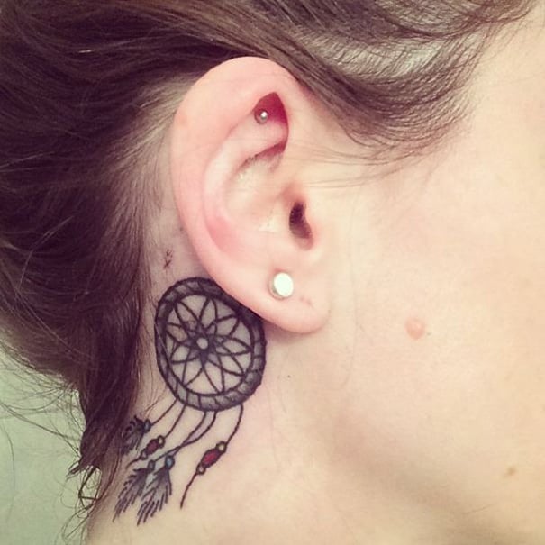 Chica con un tatuaje atrás de la oreja en forma de atrapasueños