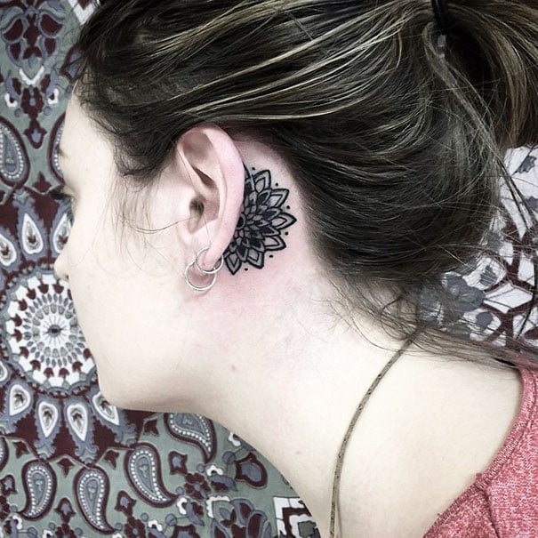 Chica con un tatuaje atrás de la oreja en forma de mandala