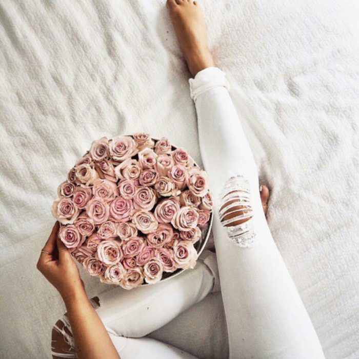 mujer con flores en la cama 