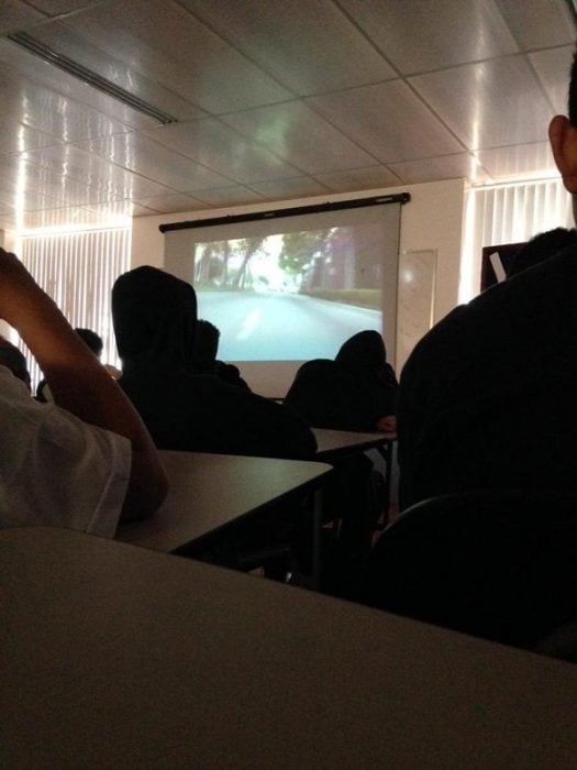 Chicos viendo una película en clase