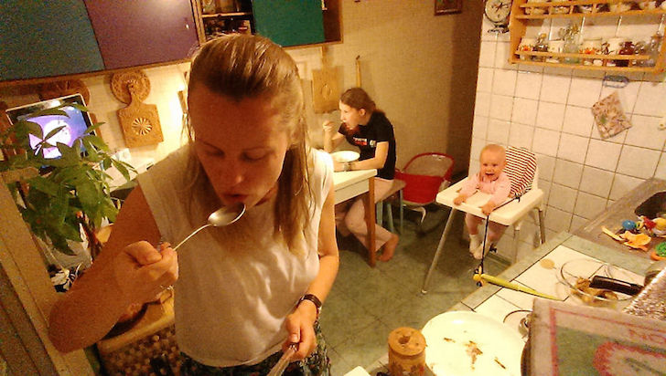 madre comiendo, atras hija comiendo y bebe en silla