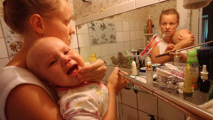 madre con bebe enfrente de baño de espejo 