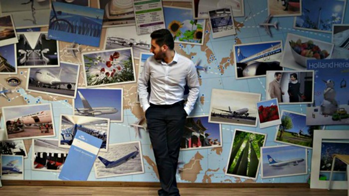 hombre en frente de postales y mural 