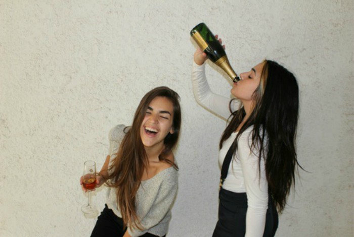 amigas tomando de botella de vino riéndo 