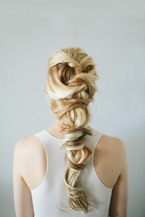 chica rubia de espaldas con una trenza 