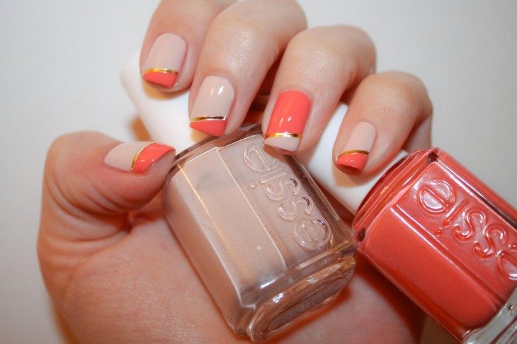 manos de mujer con las uñas pintadas y esmalte naranja 
