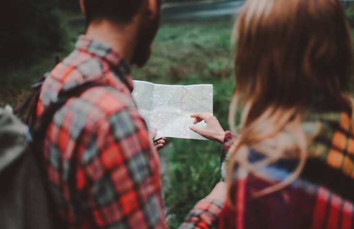 pareja mirando un mapa en el bosque 