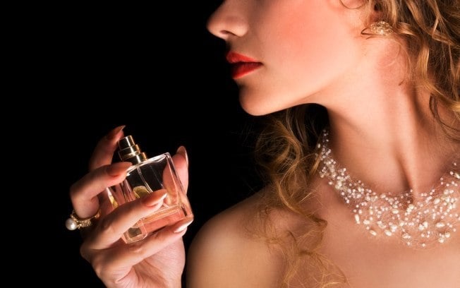 mujer rociando perfume de noche