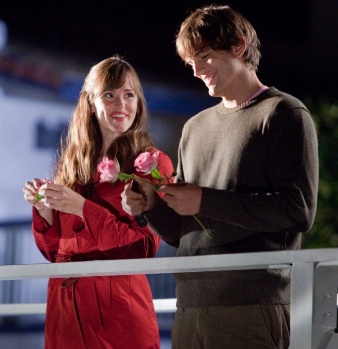 pareja en un muelle flores en la mano sonriendo 