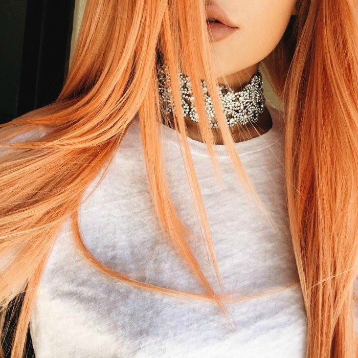 mujer collar labios cafe y cabello naranja 