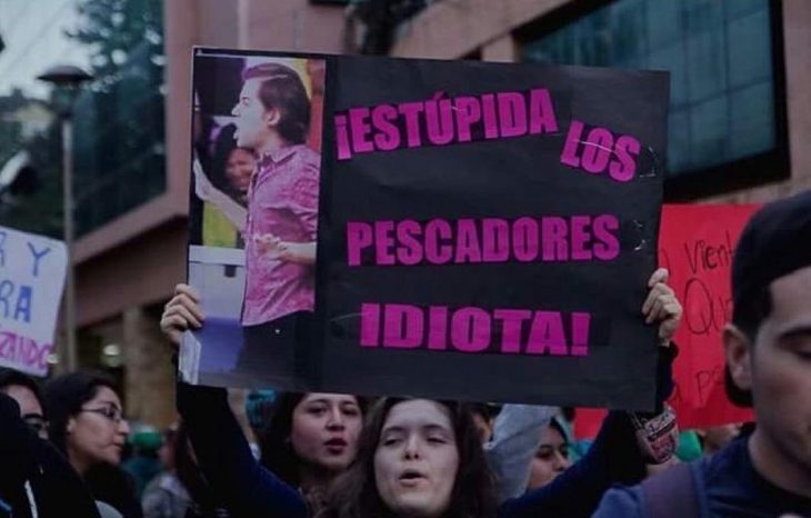 mujer con pancarta y foto de chico estúpida mi pelo idiota