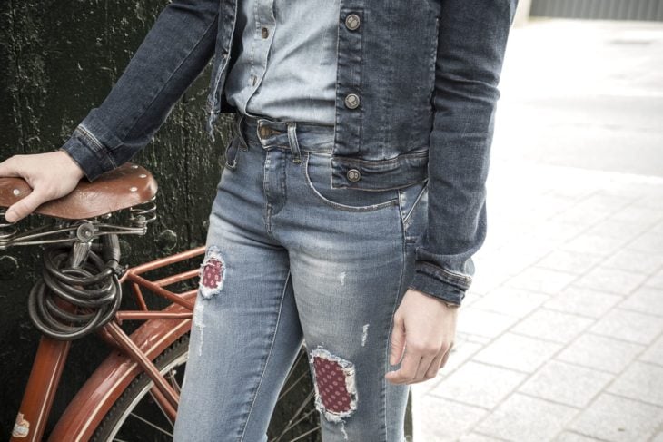 Mujer con jeans rotos y parchados