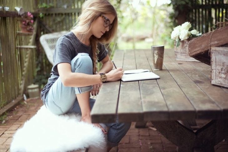 chica escribiendo al aire libre