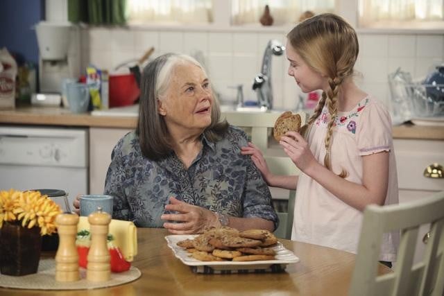 abuela y nieta comiendo galletas en la cocina