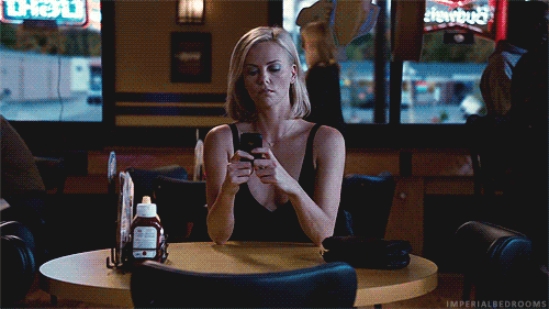 gif chica sola en restaurante con celular